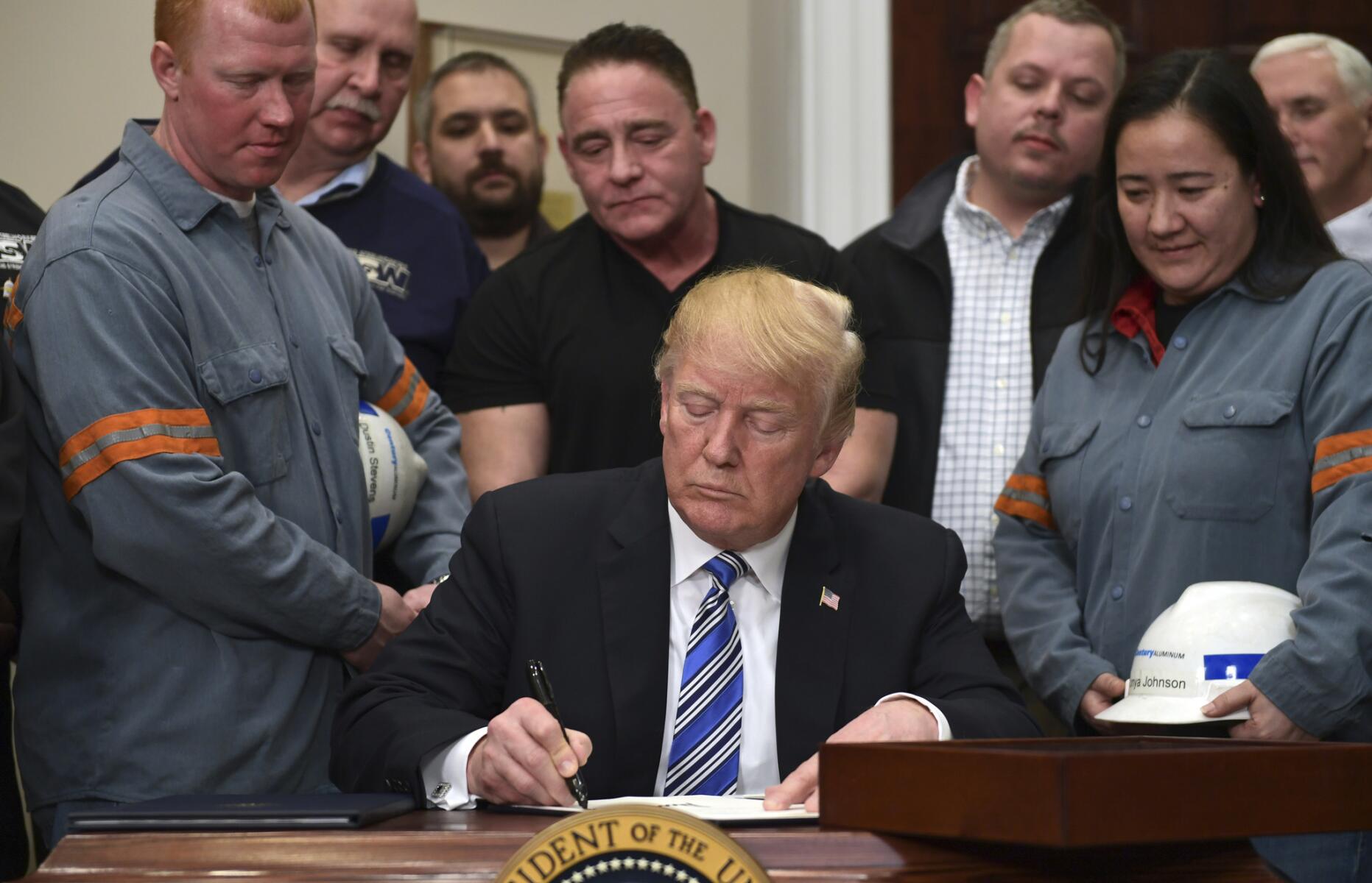 Flanqueado por obreros metalúrgicos, Donald Trump firma el decreto presidencial imponiendo aranceles a la importación de acero y aluminio el 8 de marzo del 2018 en la Casa Blanca. La medida es resistida incluso dentro de su partido Republicano y puede generar una guerra comercial.